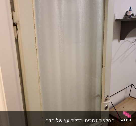 דלת עם זכוכית חלבית במסגרת עץ לבנה